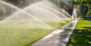 Sprinklers,Spray,Sheets,Of,Water,On,Side,Wall,And,Green