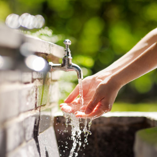 Closeup,Photo,Of,Woman,Washing,Hands,In,A,City,Fountain